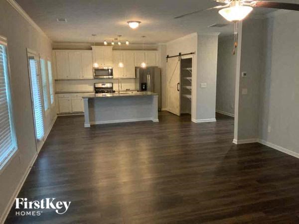 an empty living room and kitchen with wood floors