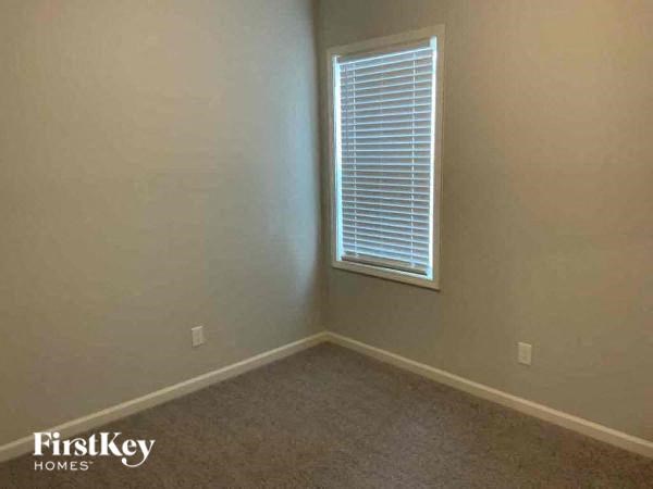 a empty room with a window and a carpet