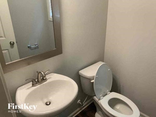 a bathroom with a toilet and a sink and a mirror