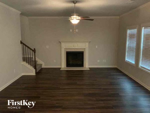 a empty living room with a fireplace and a ceiling fan