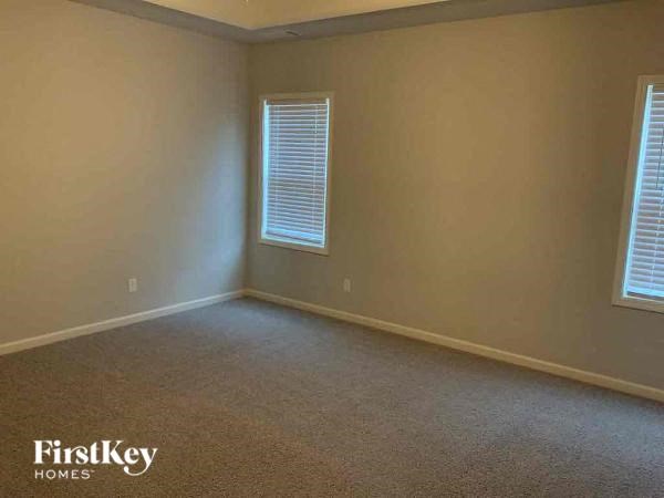 an empty room with two windows in it