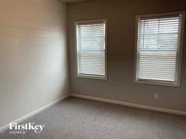 a room with two windows and a carpet
