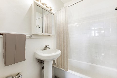 A white sink in a bathroom with a mirror above it.