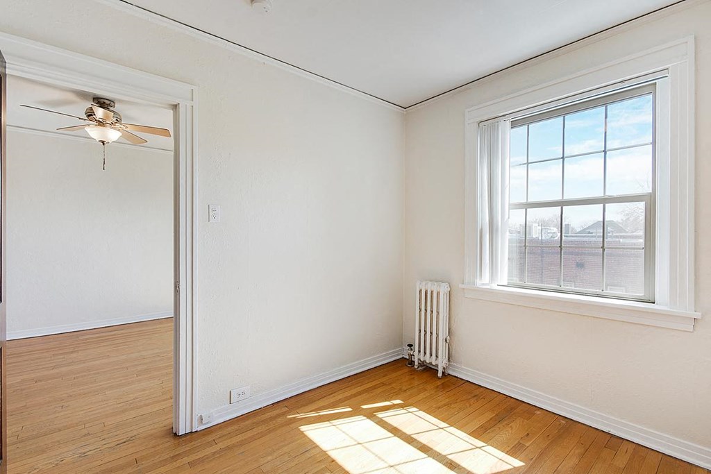A living room with a grey couch, a white coffee table, and a ceiling fan.