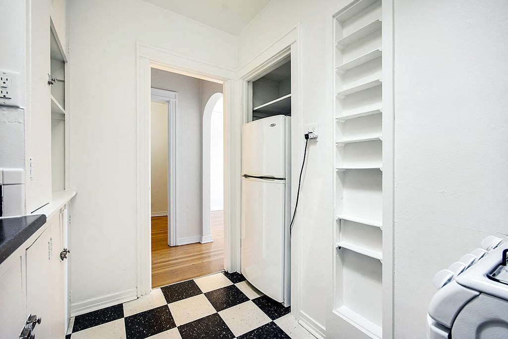 A black and white checkered floor in a white kitchen.