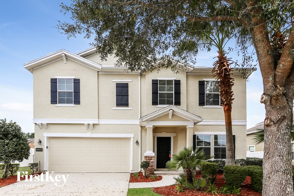 a white house with a tree in front of it
