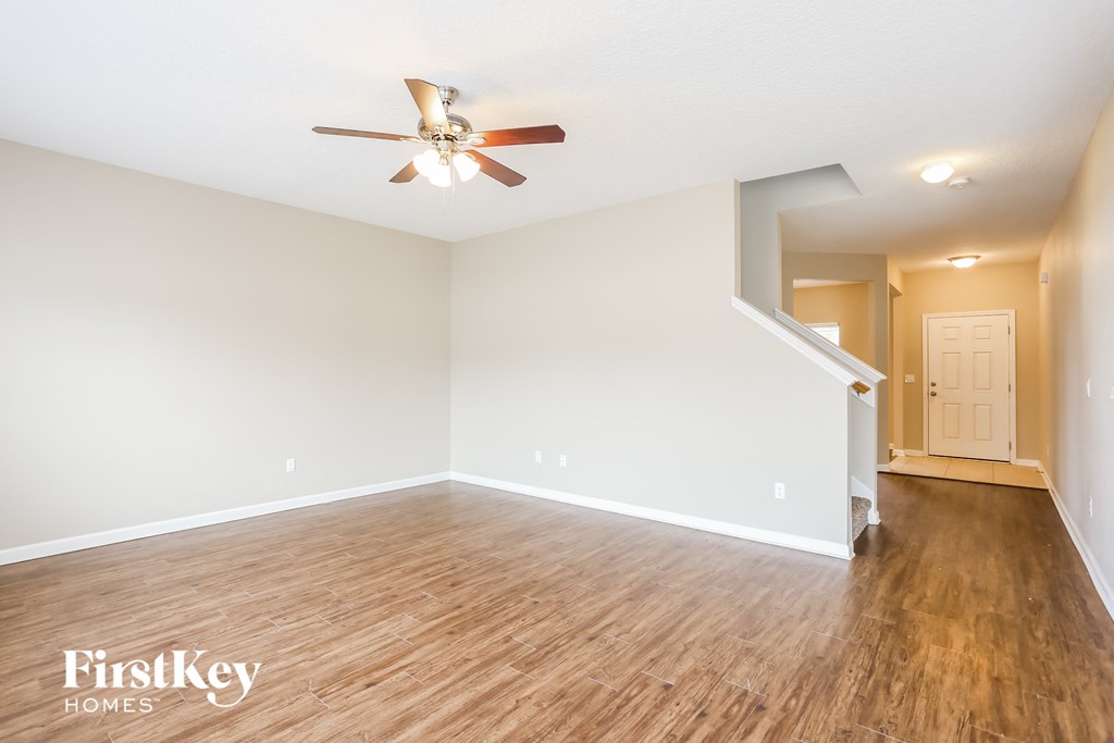 the living room with hardwood floors and a ceiling fan