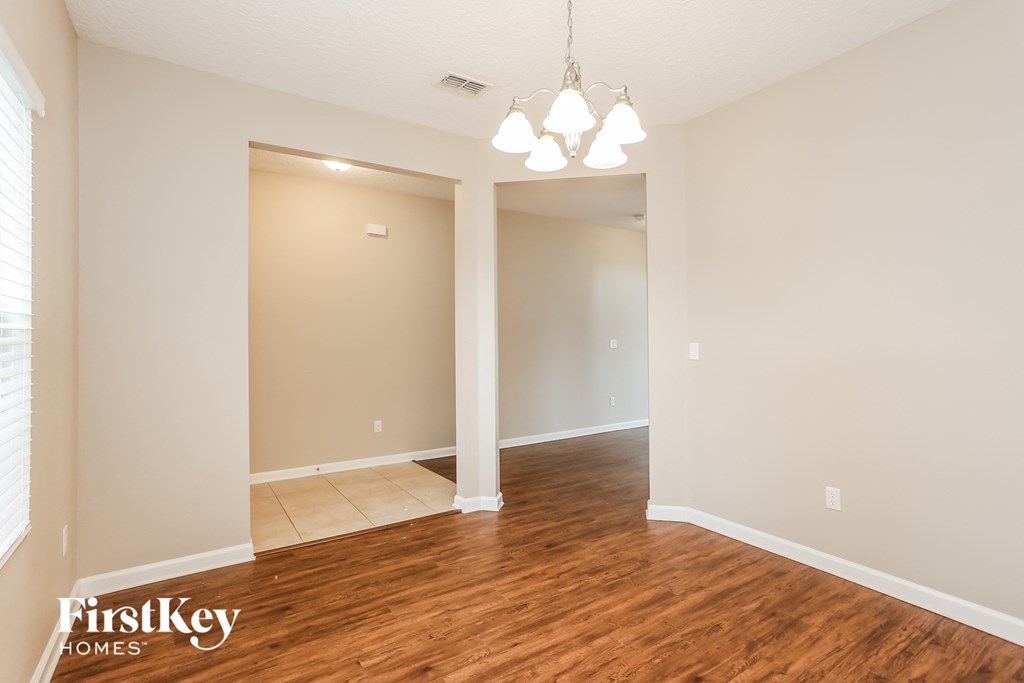 the living room and dining room of an empty house
