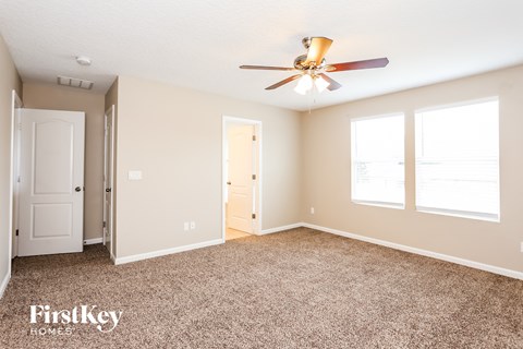 a living room with carpet and a ceiling fan