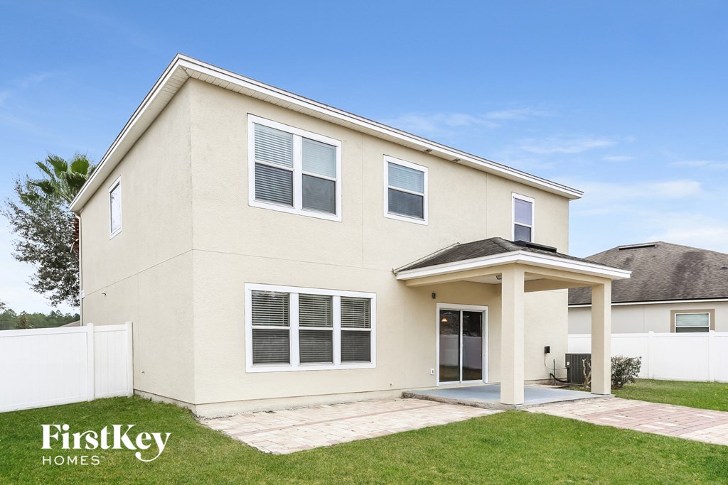 a white house with a porch and a lawn