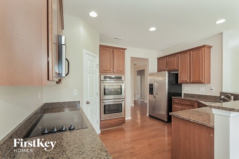 a kitchen with granite counter tops and wooden cabinets and stainless steel appliances