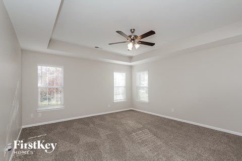 a living room with carpet and a ceiling fan