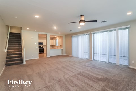 A spacious living room with a staircase leading to the upper floor.