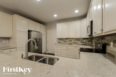 A kitchen with a sink and a refrigerator.