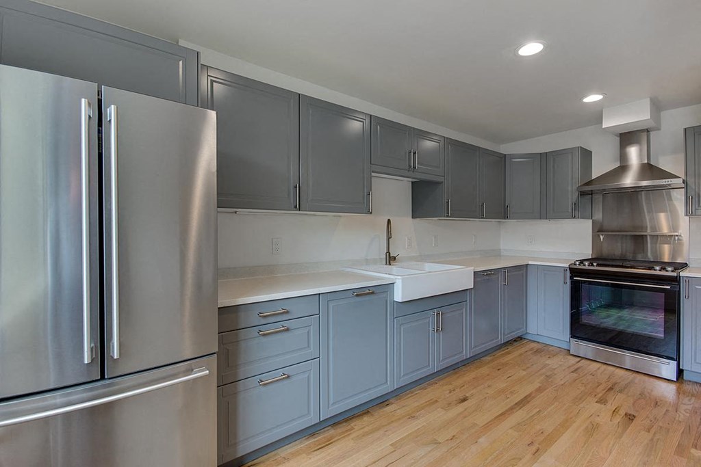 a kitchen with blue cabinets and stainless steel appliances