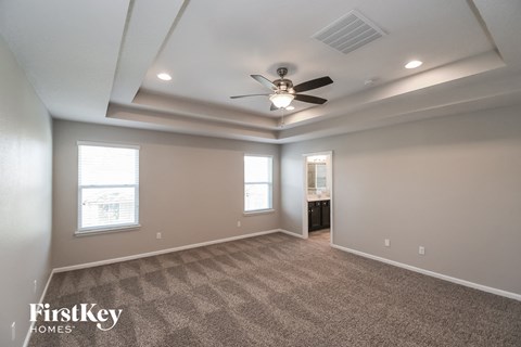 a living room with carpet and a ceiling fan