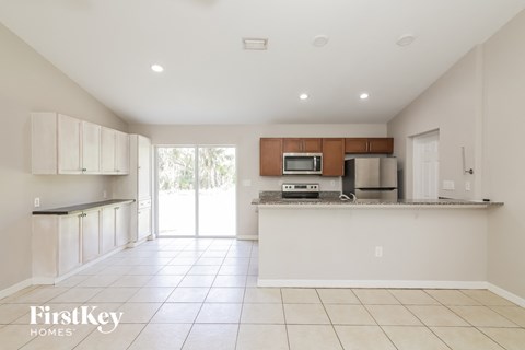 A kitchen with white cabinets and a tiled floor.