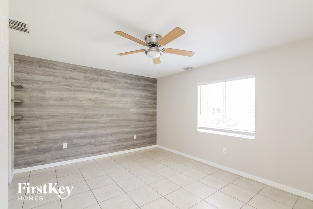 A room with a ceiling fan and a window.
