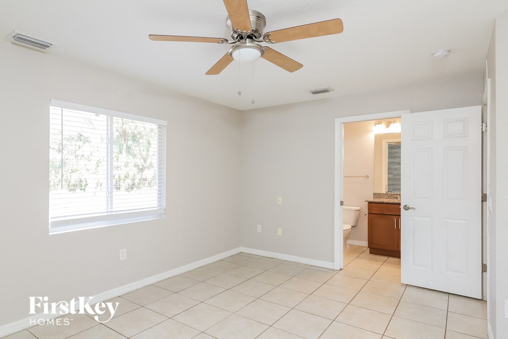 A room with a ceiling fan and a window.