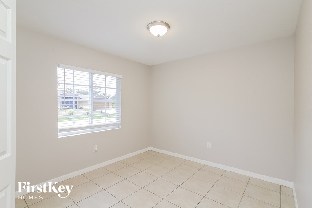 A room with a window and a tiled floor.