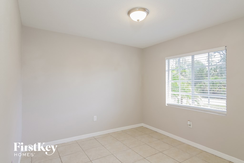 A room with a window and a tiled floor.
