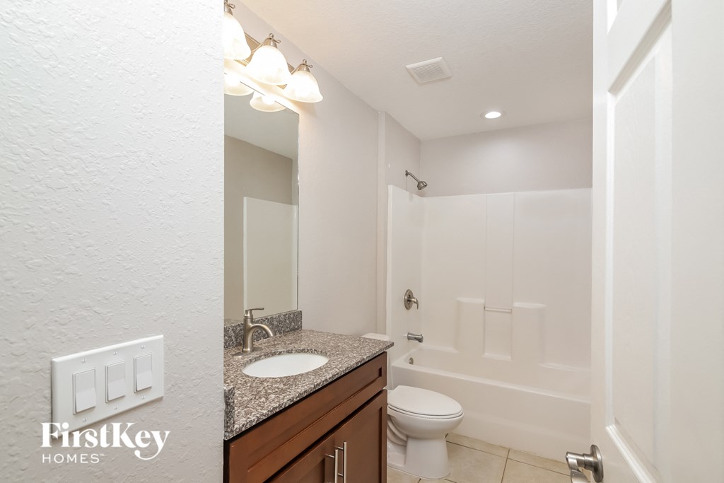 A bathroom with a sink, toilet and tub.