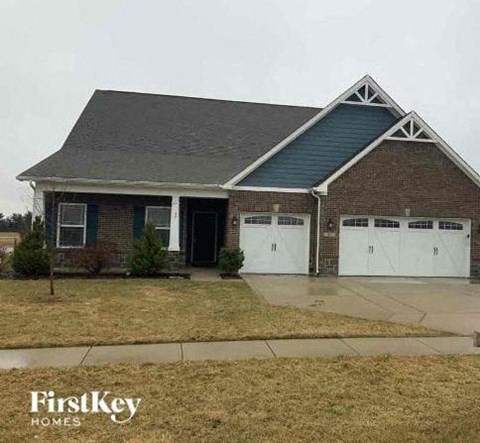 a brick house with white garage doors