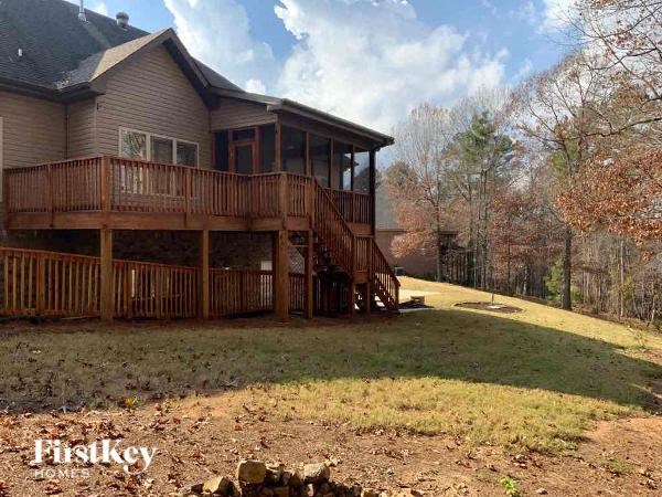 A house with a deck and a tree in the background.