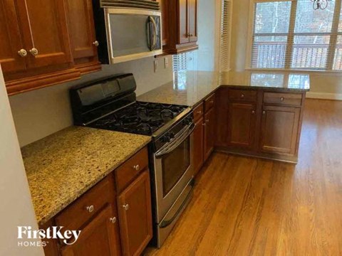 A kitchen with wooden cabinets and a granite countertop.