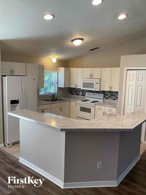 a kitchen with white cabinets and a counter top