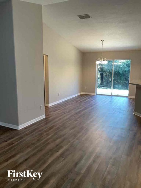 an empty living room with wood floors and a sliding glass door