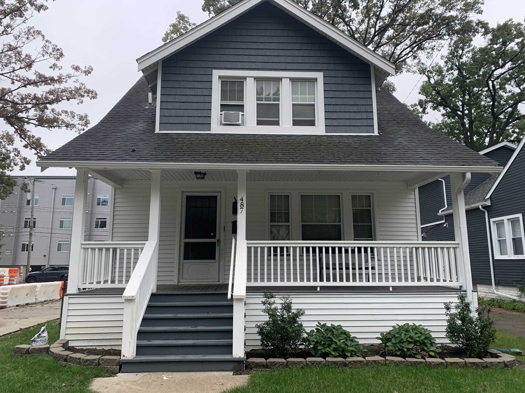 A small house with a porch and a front door.