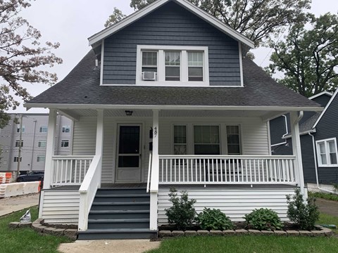 A small house with a porch and a front door.