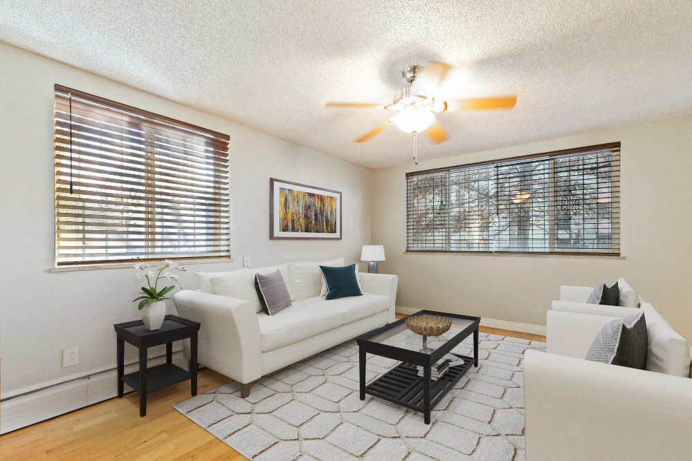 a living room with a white couch and a ceiling fan