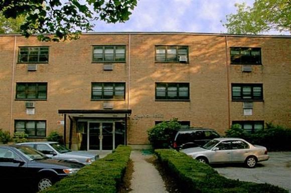a brick building with cars parked in front of it