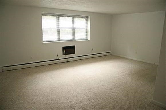 an empty room with a window and a carpet floor