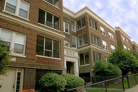 a brick building with a chain link fence in front of it