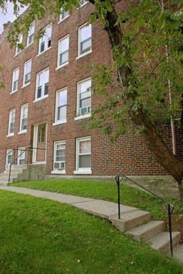 a brick building with a tree in front of it