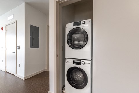 a front loading washer and dryer in a room with a door