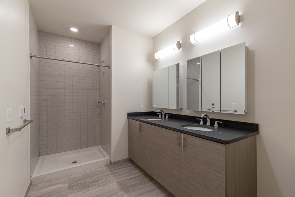 a bathroom with a large shower and a sink and mirror