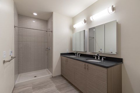 a bathroom with a large shower and a sink and mirror