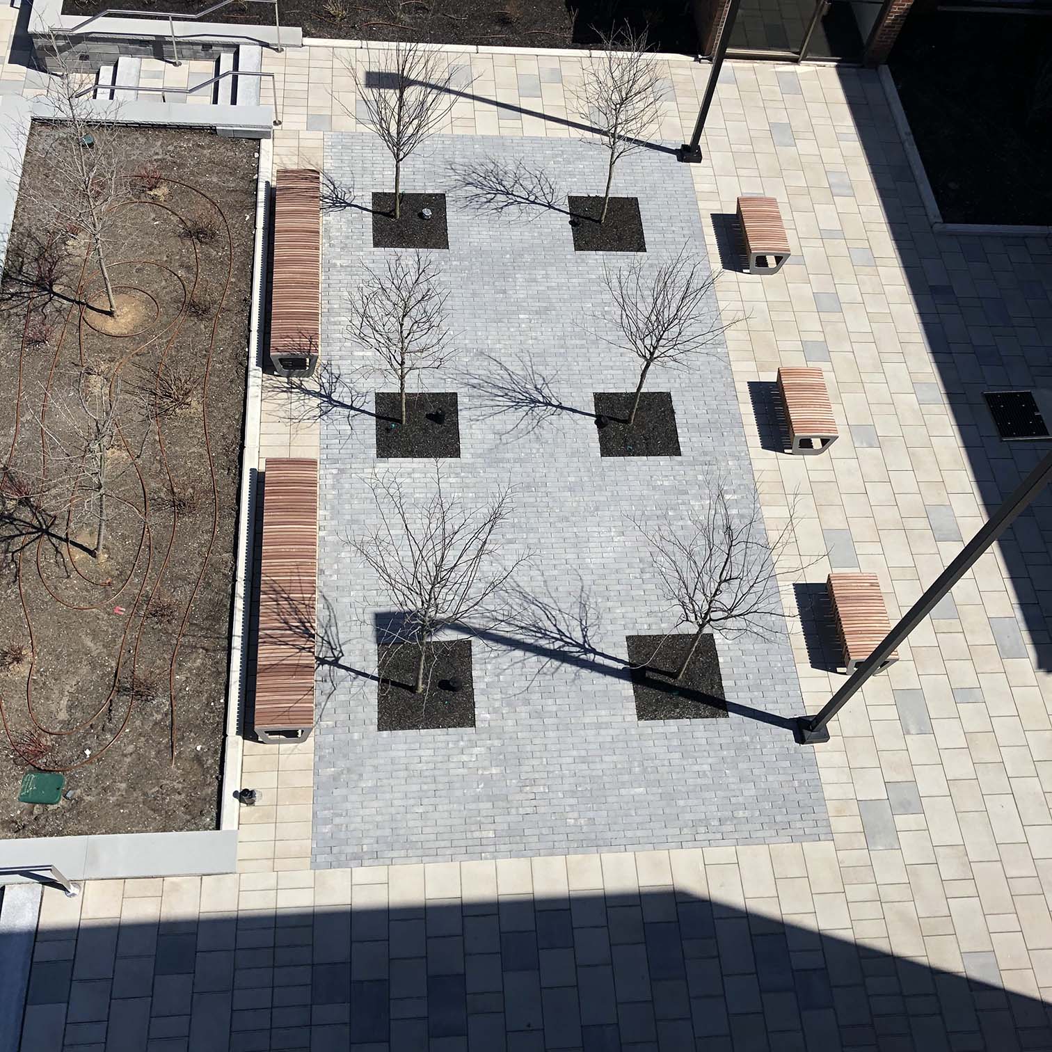 an aerial view of a courtyard with trees and benches