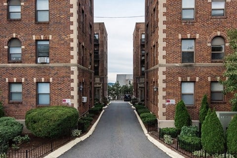 an empty street between two brick apartment buildings