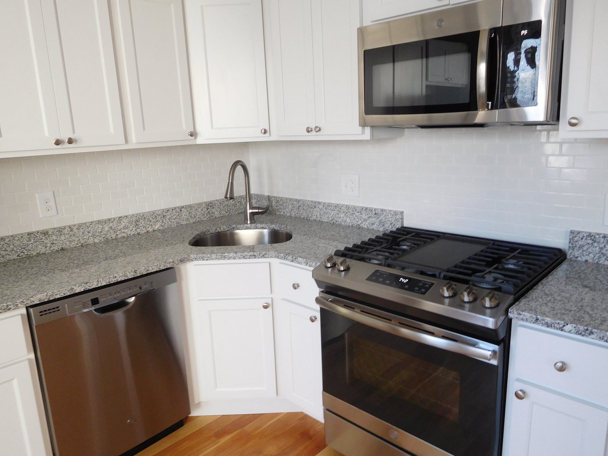 Renovated Kitchen with White Cabinets, Granite Counters, Stainless Appliances and Hardwood Floors