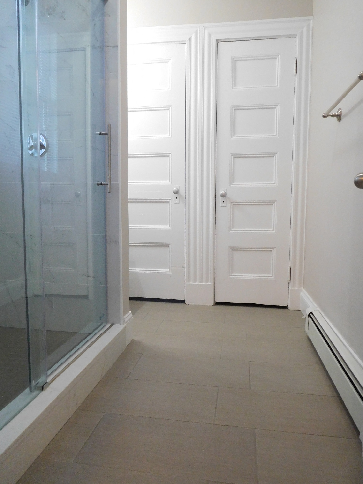 Renovated Bathroom with Gray Tile and Glass Shower Stall