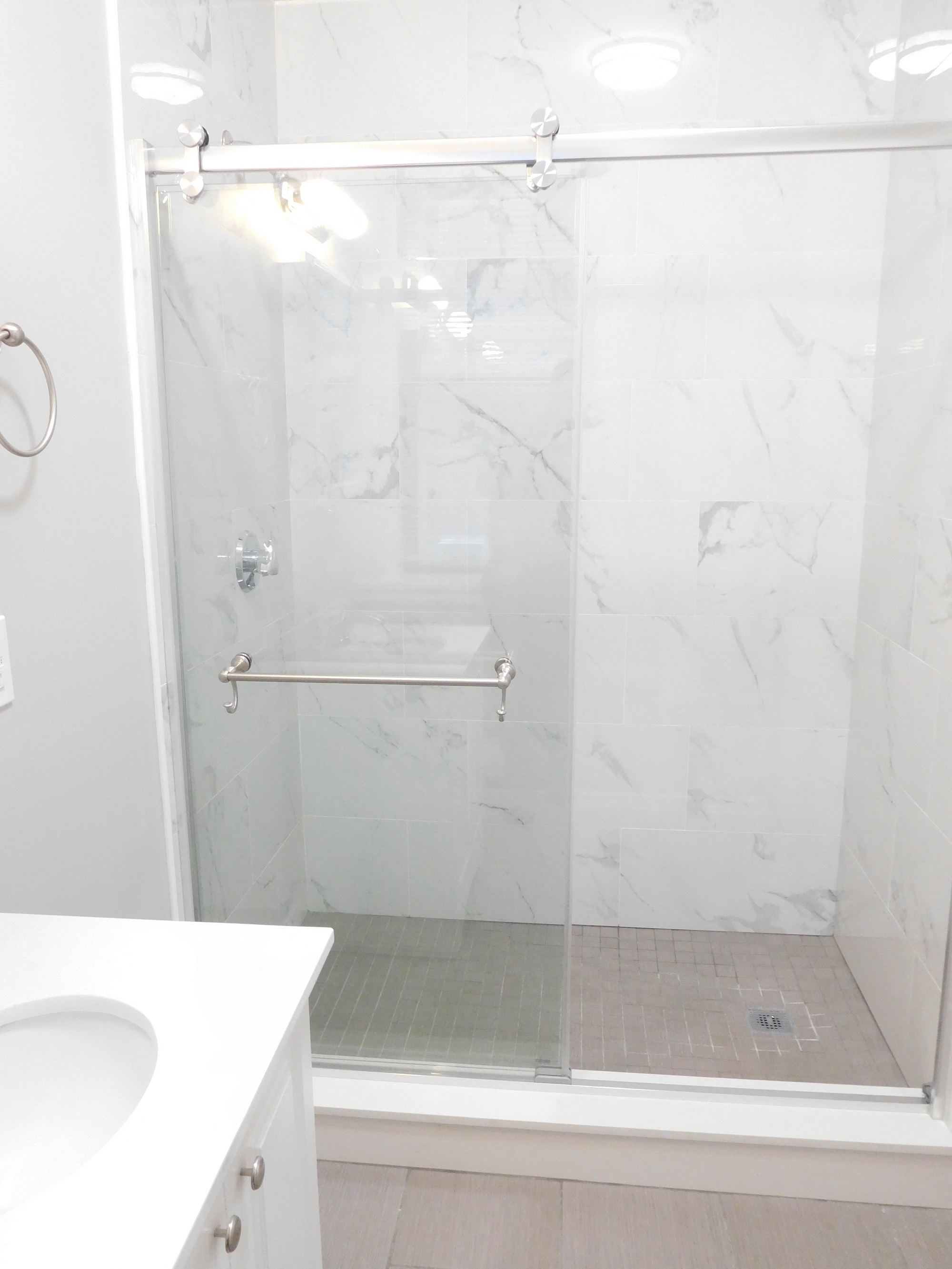 Renovated Bathroom with Gray Tile and Glass Shower Stall
