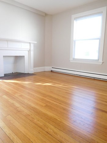 Large Living Roommate with Hardwood Floors and Decorative Fireplace