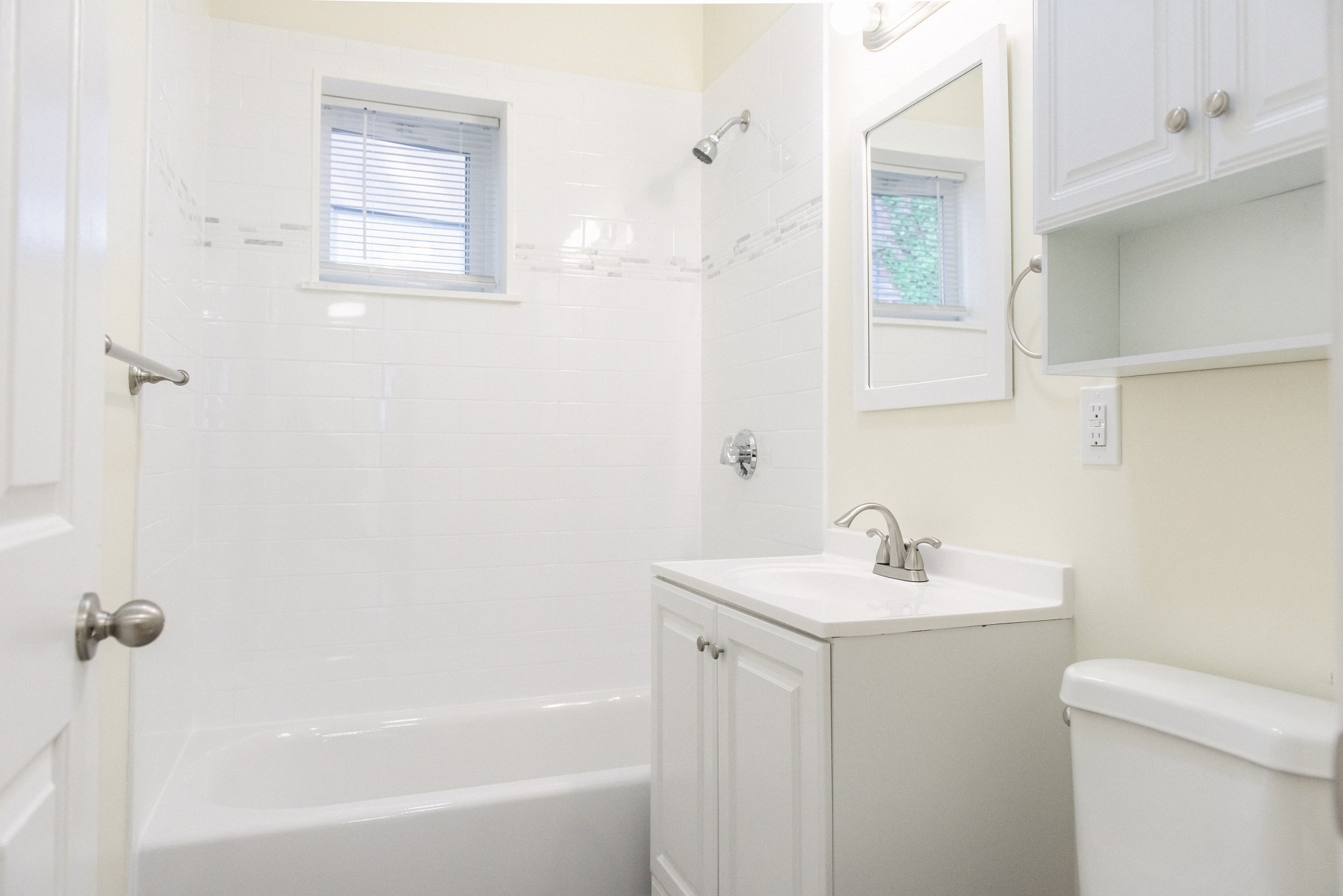Updated Bathroom with Bathtub/ Shower Combination with White Tiles