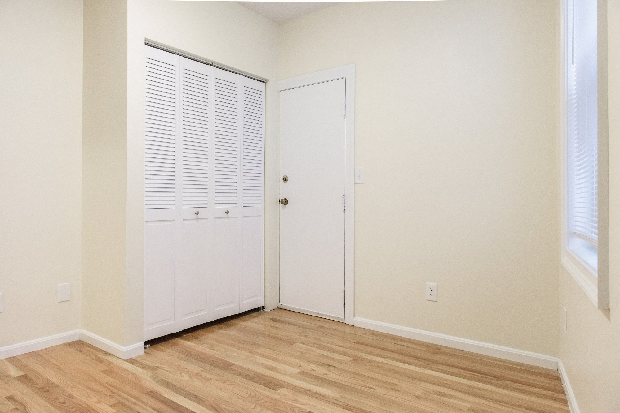 Bedroom with Hardwood Floors, Closet and Emergency Exit Door