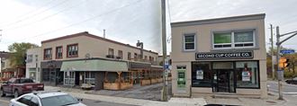 the corner of a street with a building and a coffee shop